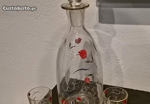 Garrafa de licor e três copos em vidro
